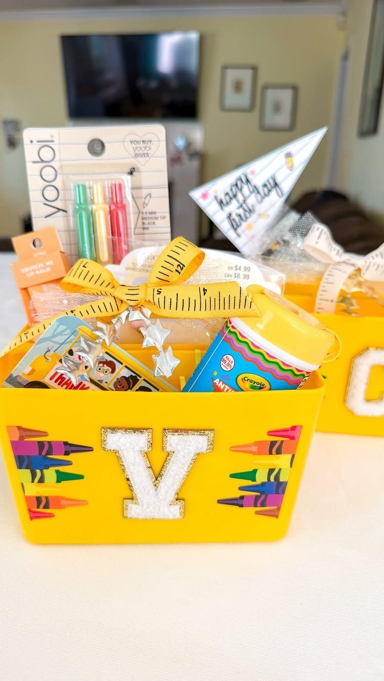 Yellow gift bin filled with school supplies and snacks, decorated with crayon graphics.