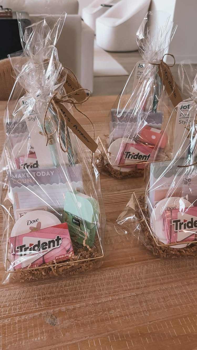 Gift bags containing gum, soap, and a motivational card on a wooden table.