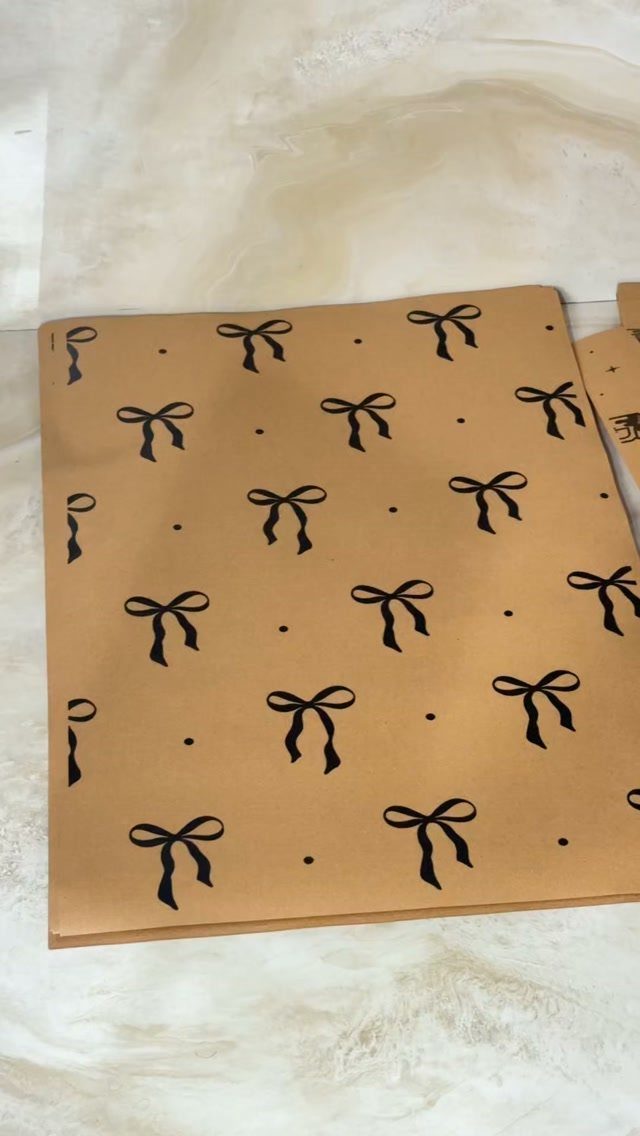Brown kraft paper with a printed pattern of black bows and dots.