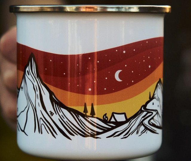 White enamel camping mug with a mountain landscape and crescent moon illustration.