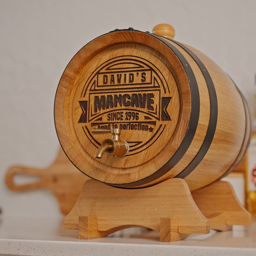 Small wooden whiskey barrel with personalized man cave engraving on a wooden stand