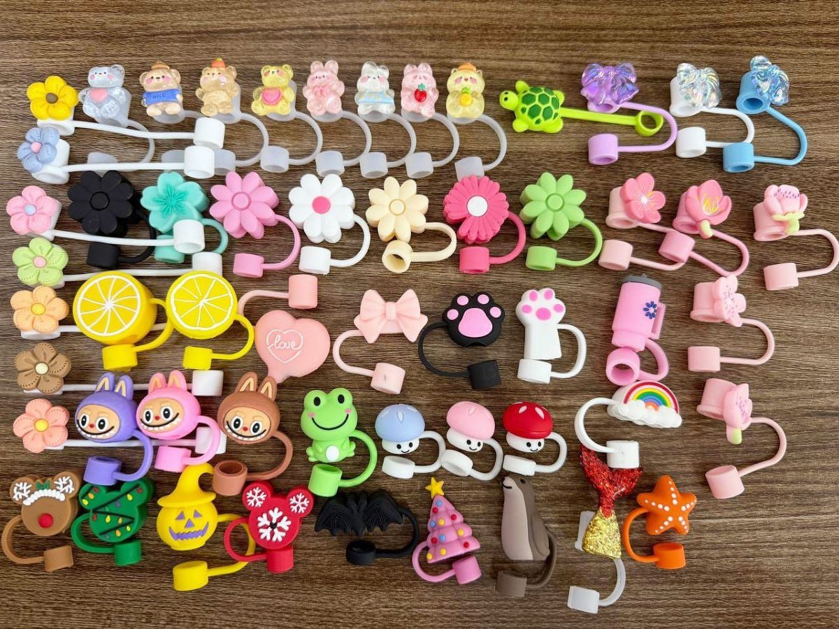 Colorful cable organizers with animal and flower charms on a wooden table.