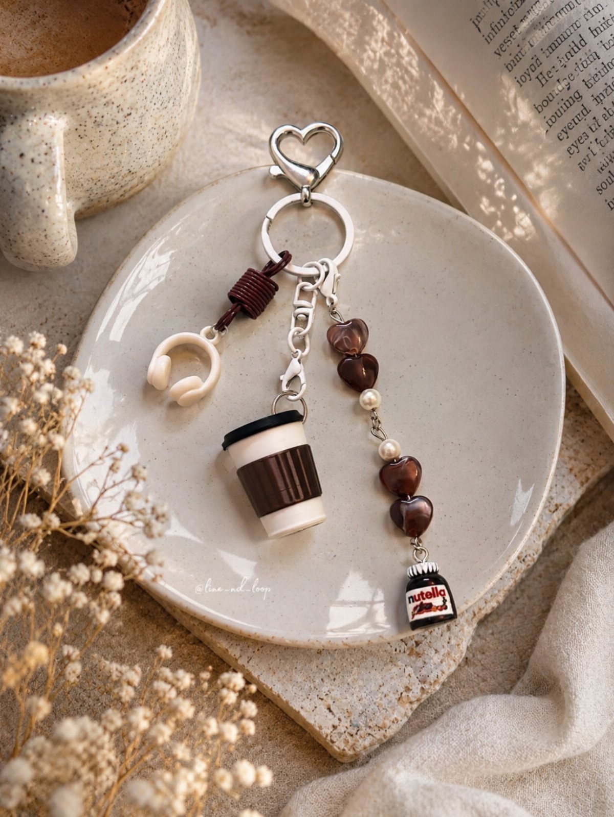 Keychain with coffee and Nutella charms resting on a white ceramic plate.