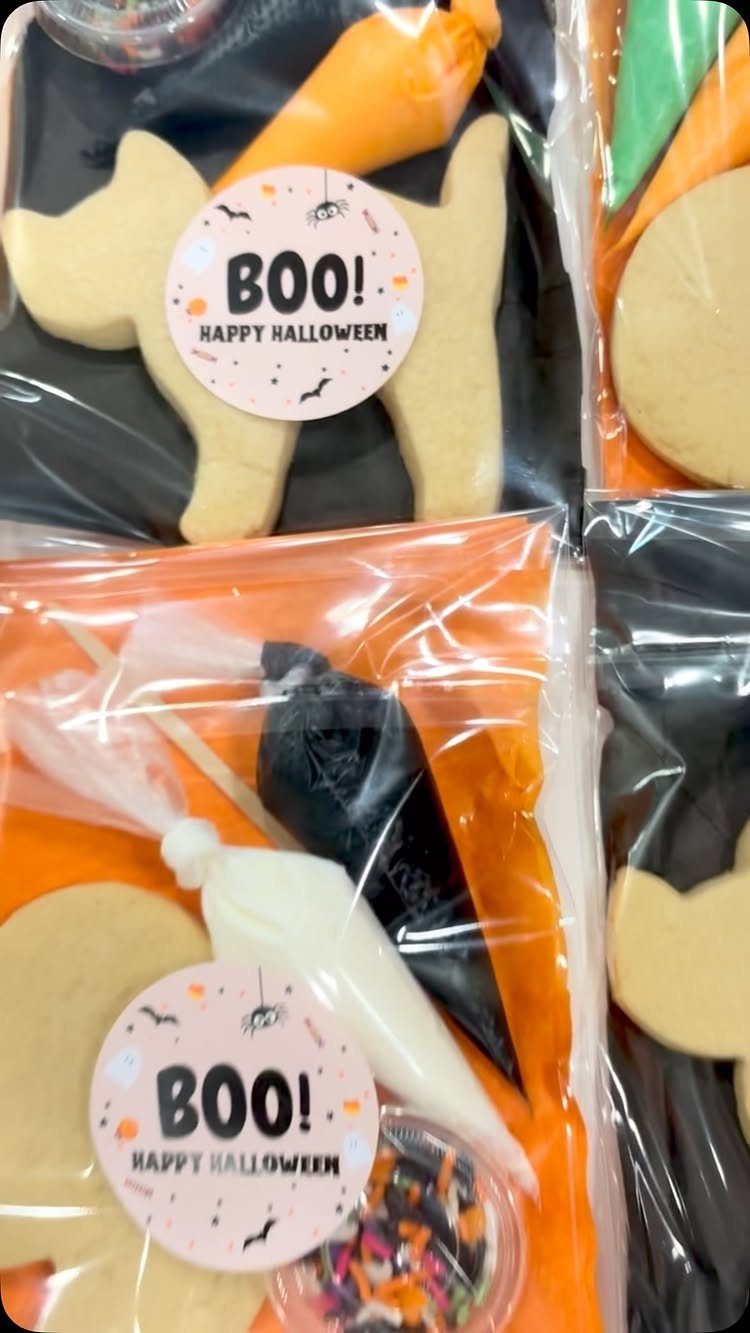 Halloween cookie kits with plain cookies, frosting piping bags, and colorful sprinkles.