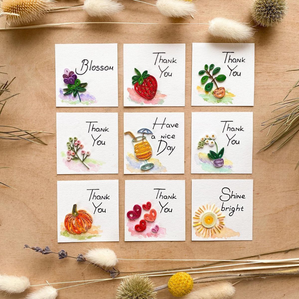 Nine small white cards with colorful embroidered illustrations and handwritten thank you notes.
