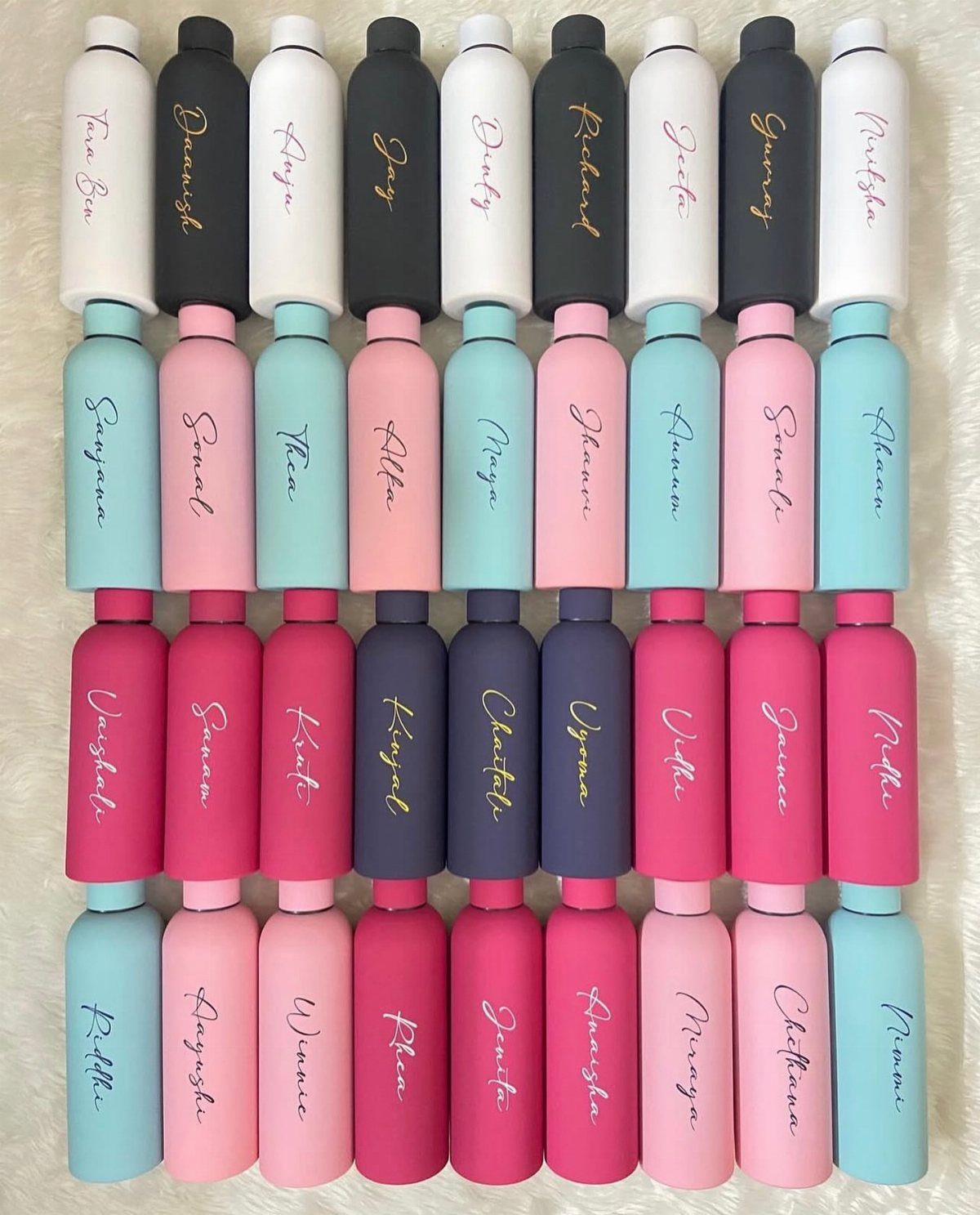 Personalized matte reusable water bottles in various colors arranged in a neat grid.