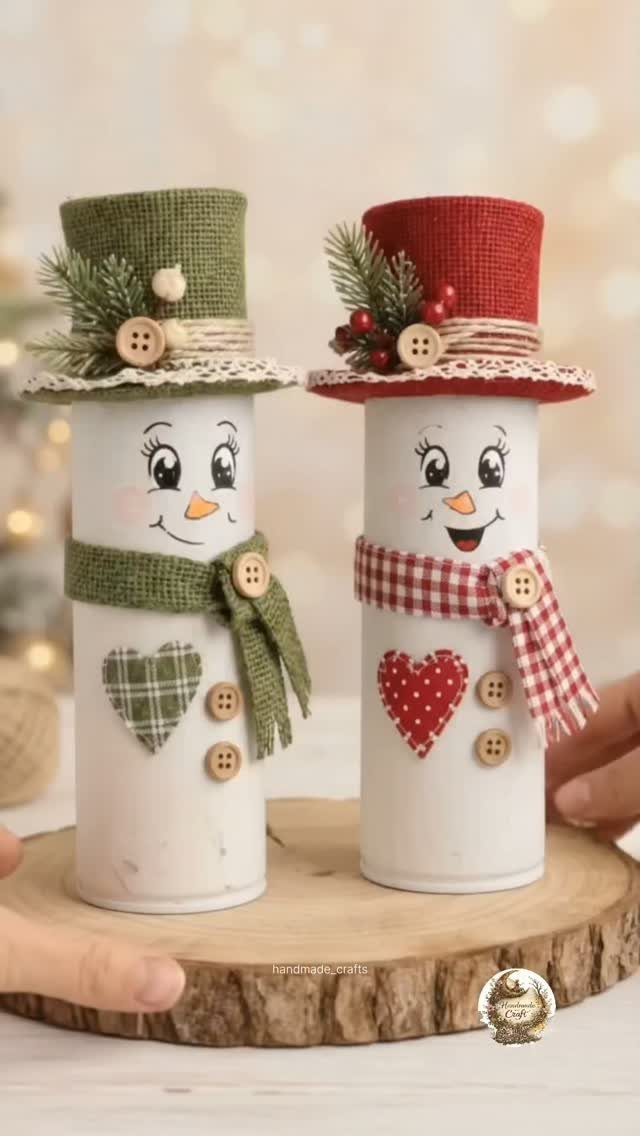 Two handmade snowman figures made from painted cans with fabric hats and scarves.