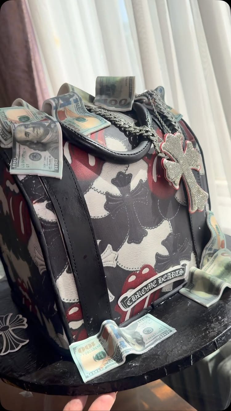 Patterned top hat decorated with US dollar bills and a sparkling cross necklace.