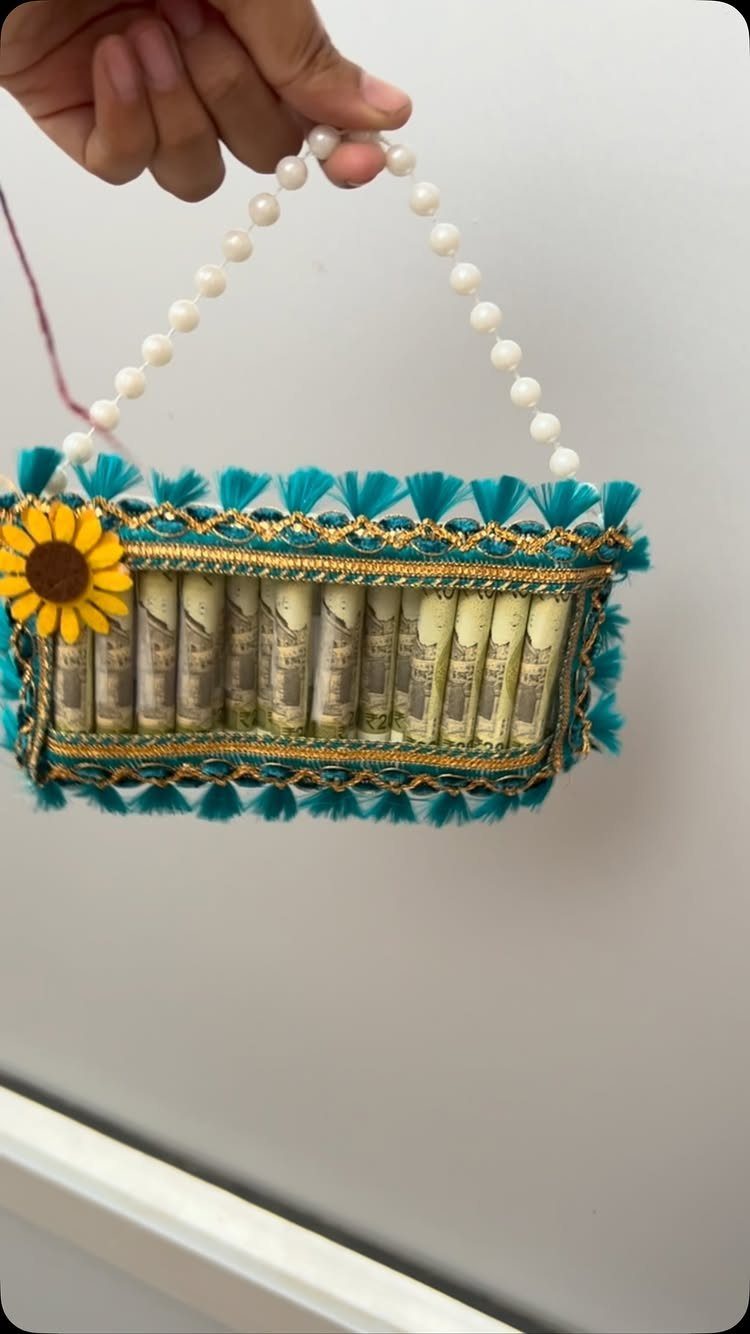 Turquoise decorative bag filled with rolled dollar bills and a pearl handle