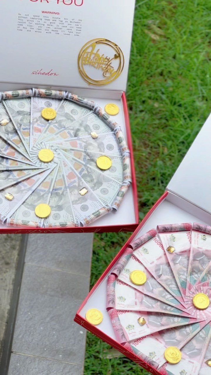 Money pizzas made of folded banknotes and gold coins in open pizza boxes.