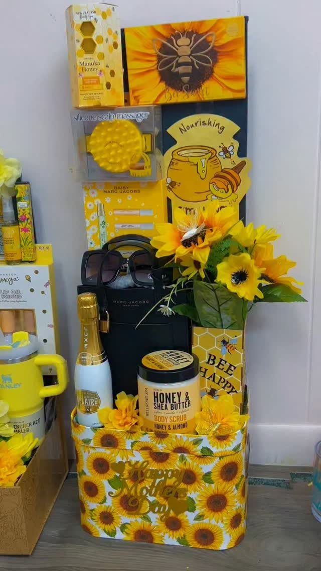 Bee-themed Mother's Day gift basket with sunflowers, honey products, and a black handbag.