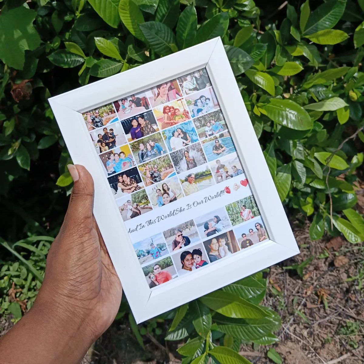 White picture frame holding a photo collage of family members against green foliage.