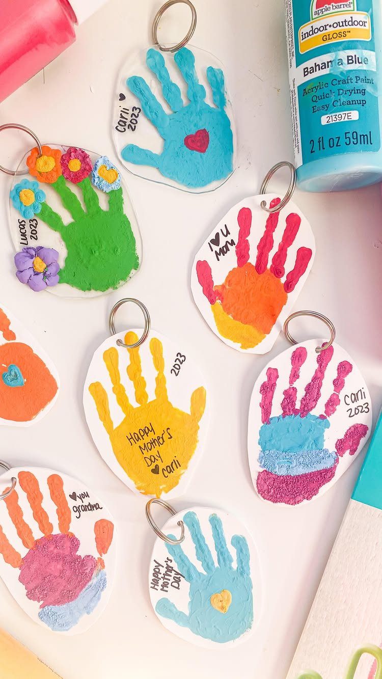 Handmade handprint keychains in various colors with Mother's Day messages and metal rings.