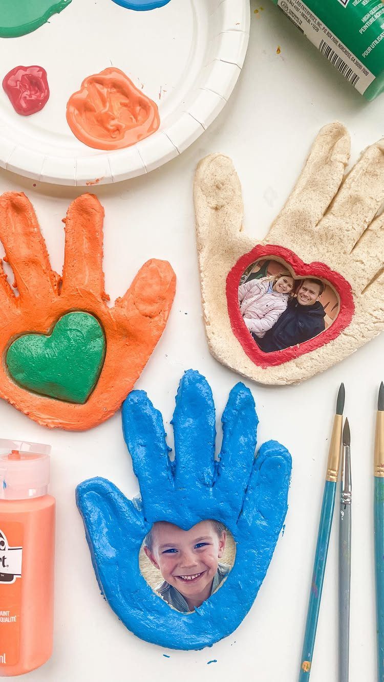 Hand-shaped salt dough keepsakes painted in orange and blue with embedded photos.