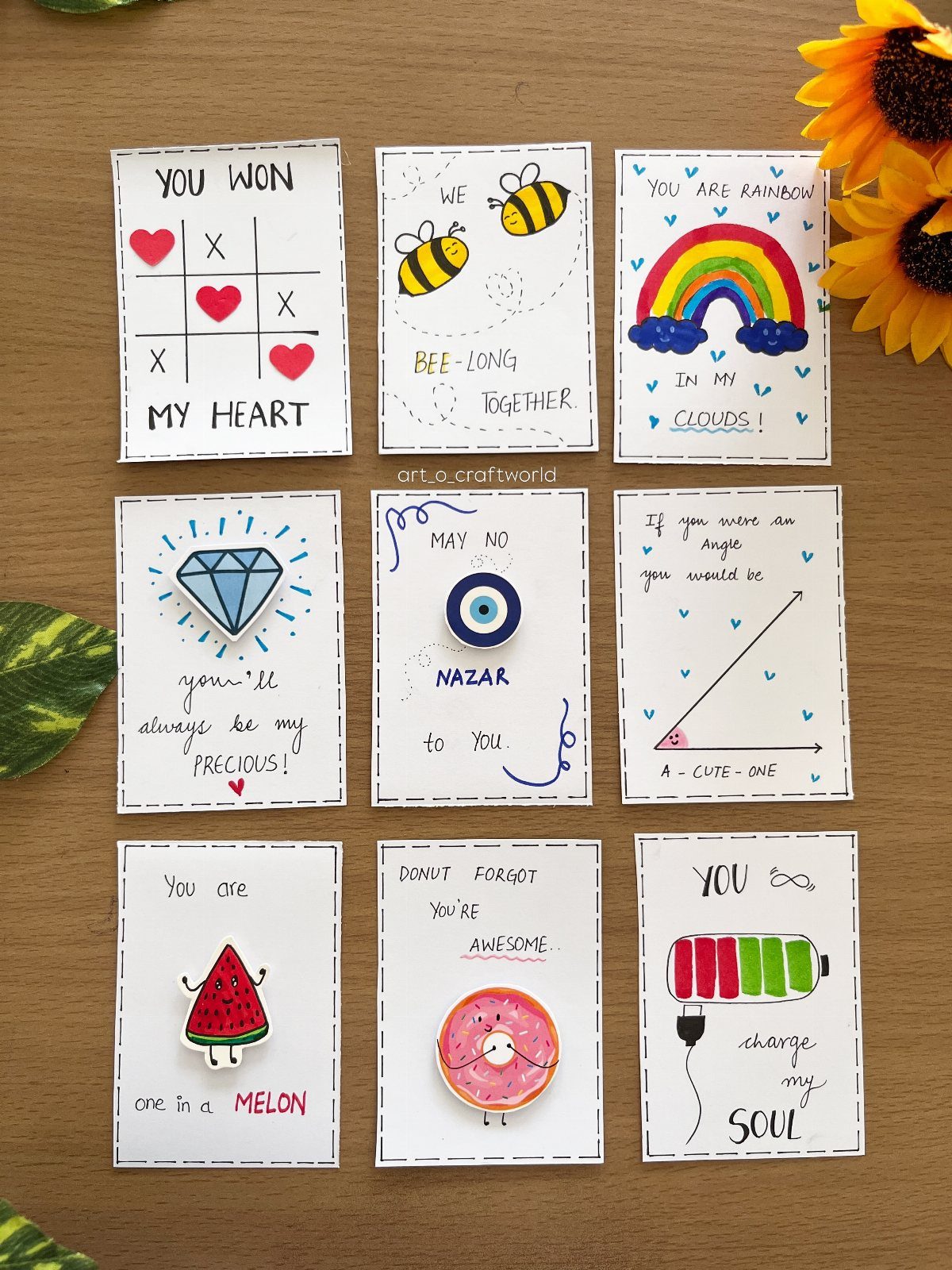 Handmade pun cards with small 3D charms arranged on a wooden table.