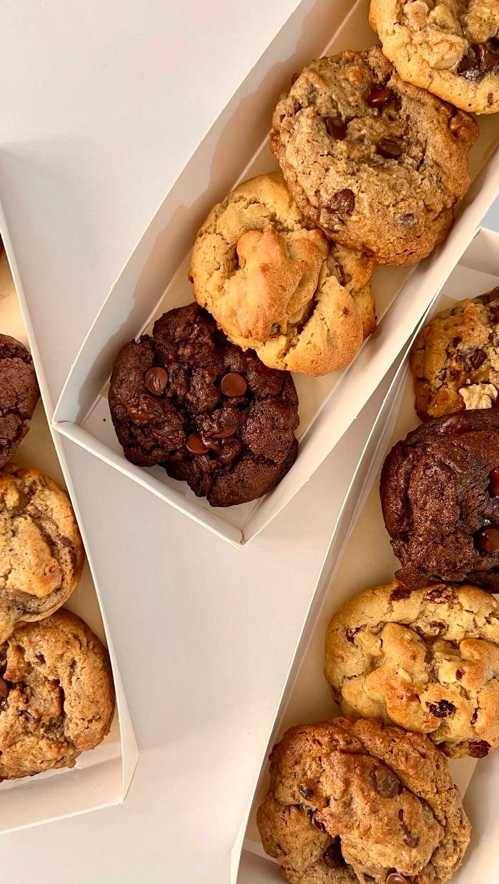 Chocolate chip and double chocolate cookies packed in white cardboard gift boxes.