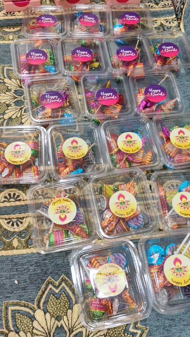 Clear plastic containers filled with colorful wrapped candies on a patterned blue fabric.