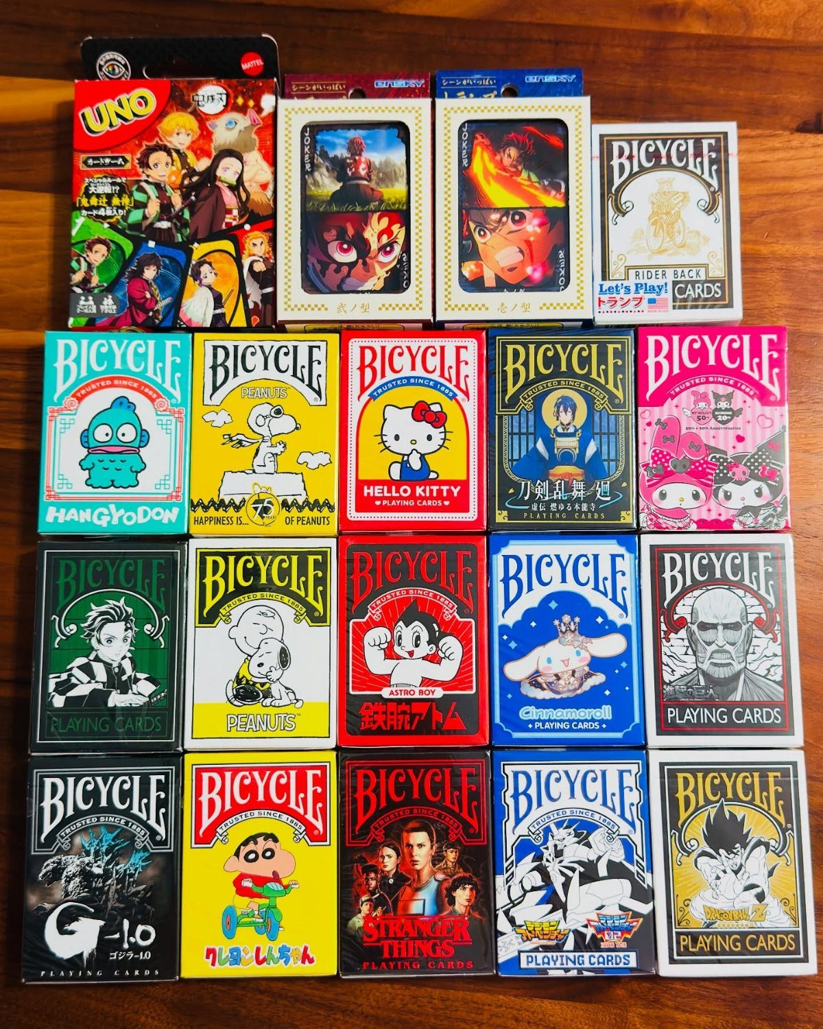 Various themed Bicycle and Uno playing card decks arranged on a wooden table.