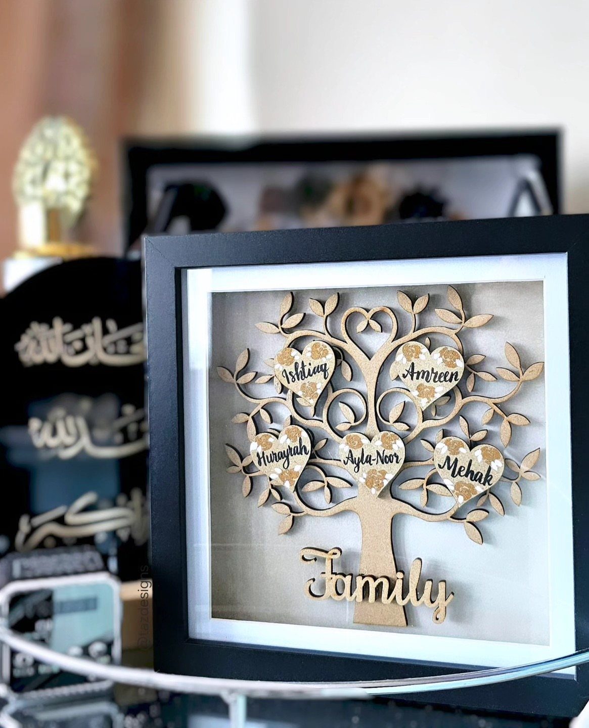 Wooden family tree sign with heart-shaped name tags in a black frame