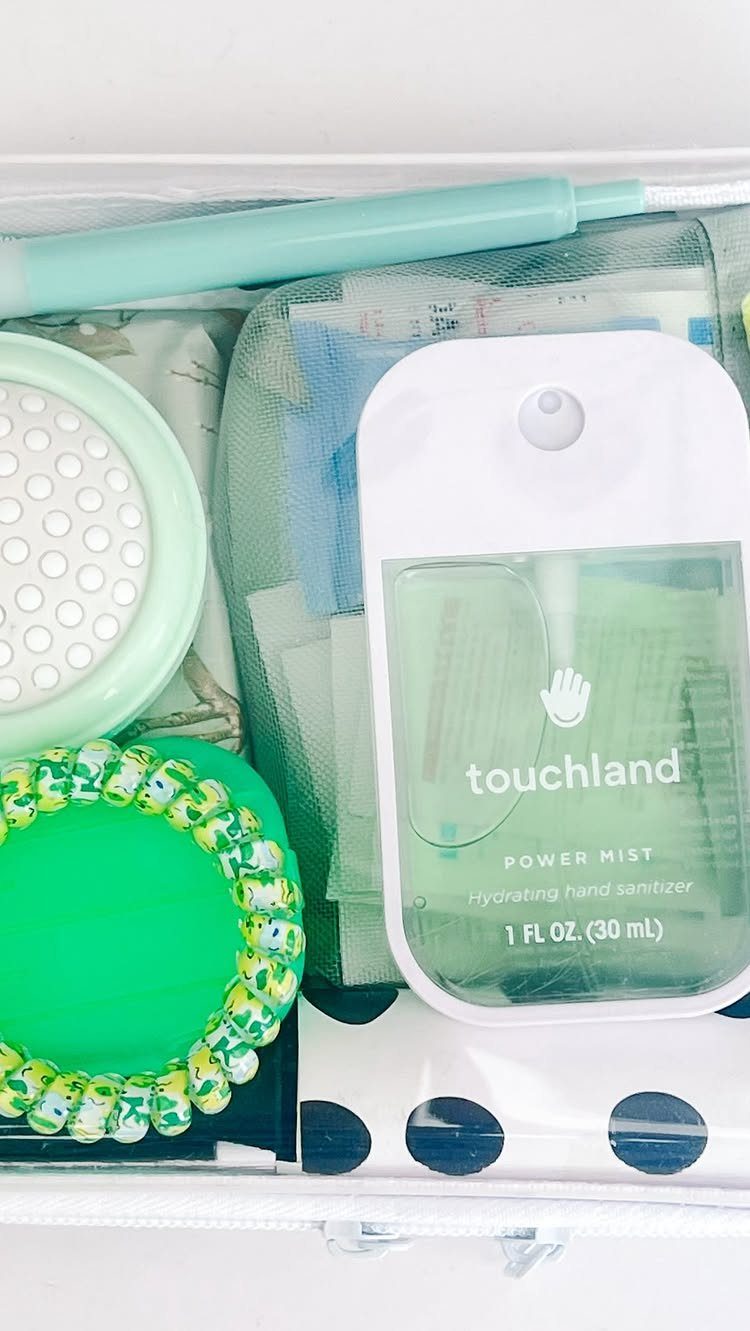 Travel kit in a clear pouch with mint green hand sanitizer and accessories.
