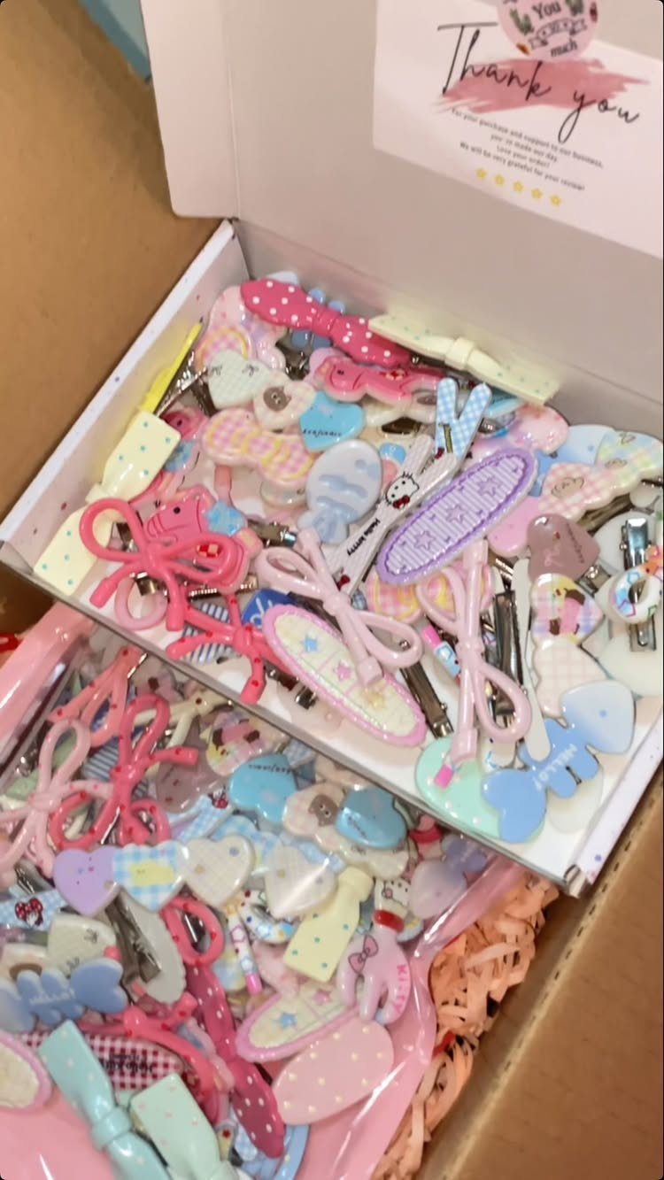 Colorful decorative hair clips with bows and hearts packed in a white box.