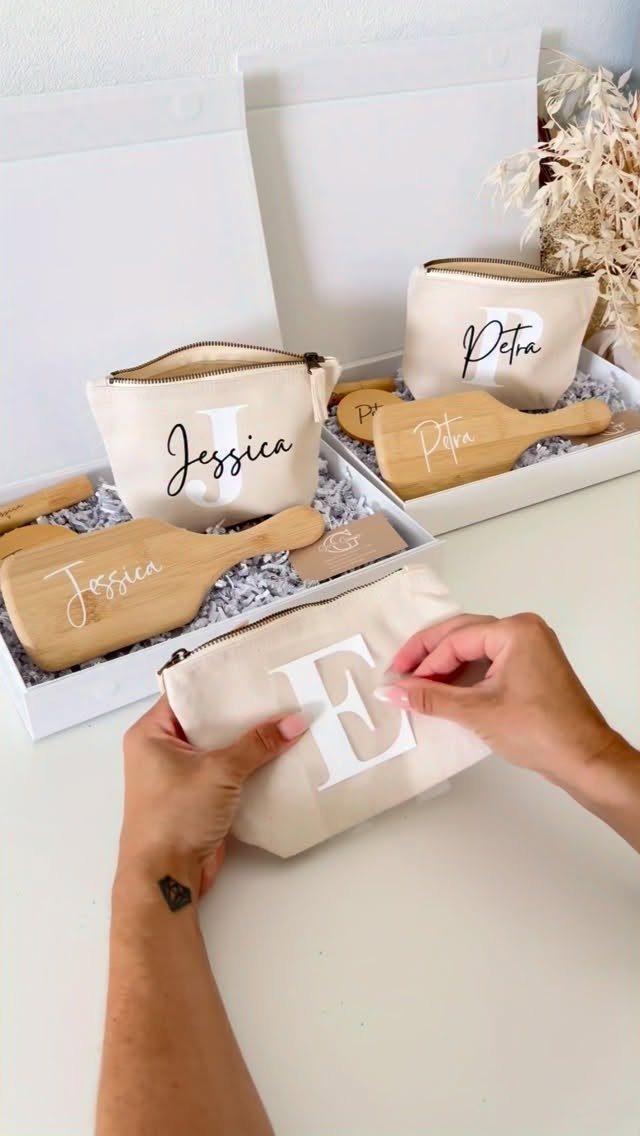 Beige canvas pouches with personalized names and initials paired with wooden spatulas in boxes.
