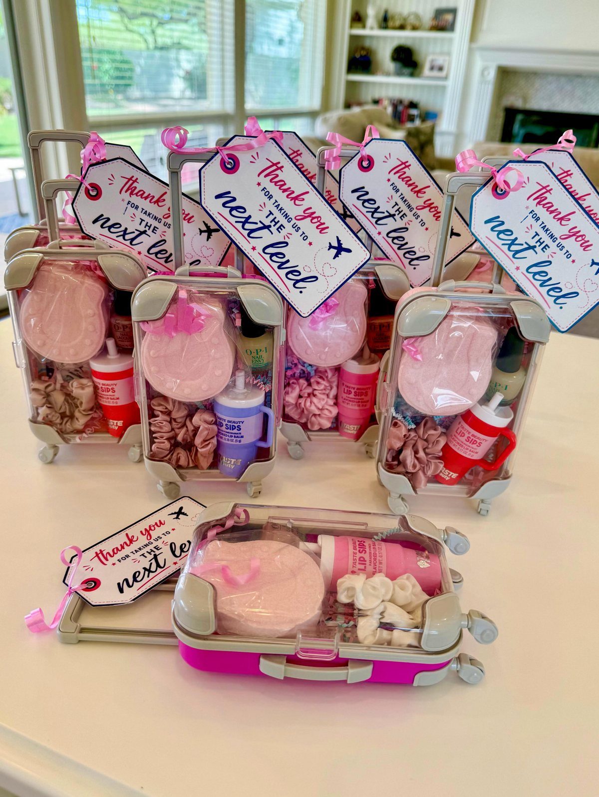 Miniature suitcase gift sets with pink items and thank you gift tags.