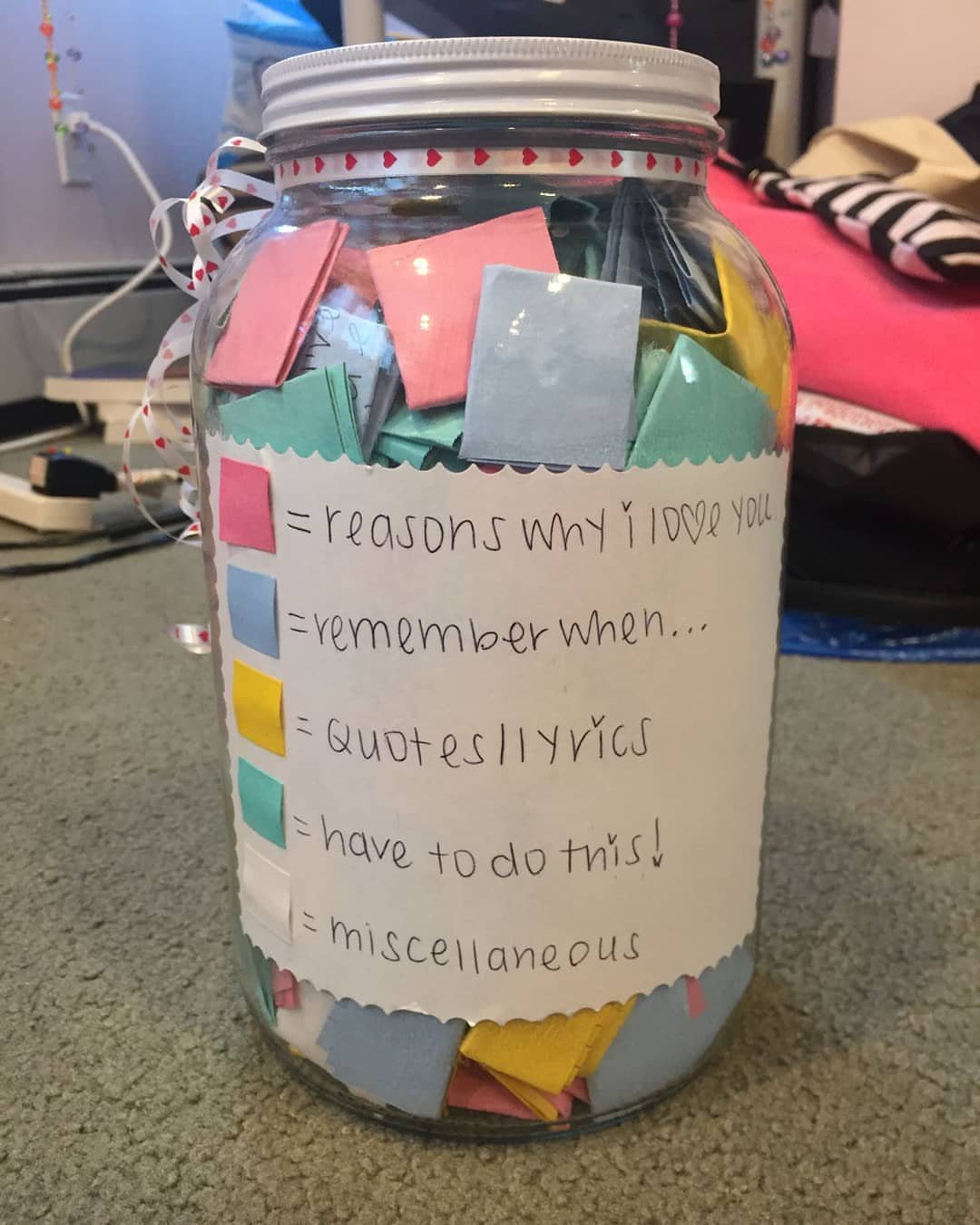 Glass jar filled with colorful folded notes and a handwritten category label.
