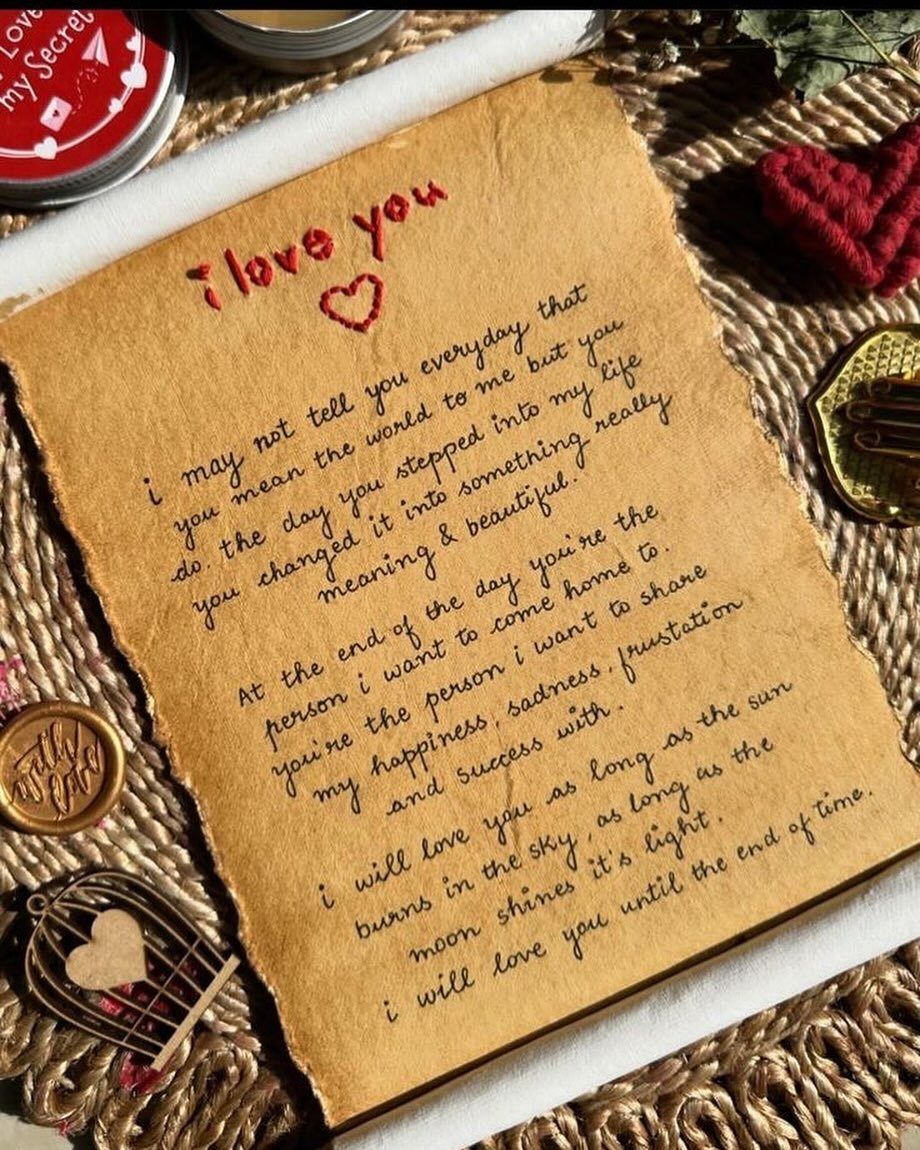 Handwritten love letter on brown parchment with red embroidery and wax seal accents.