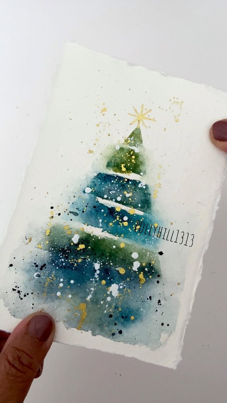 Watercolor Christmas tree card with blue and green paint and gold splatters.