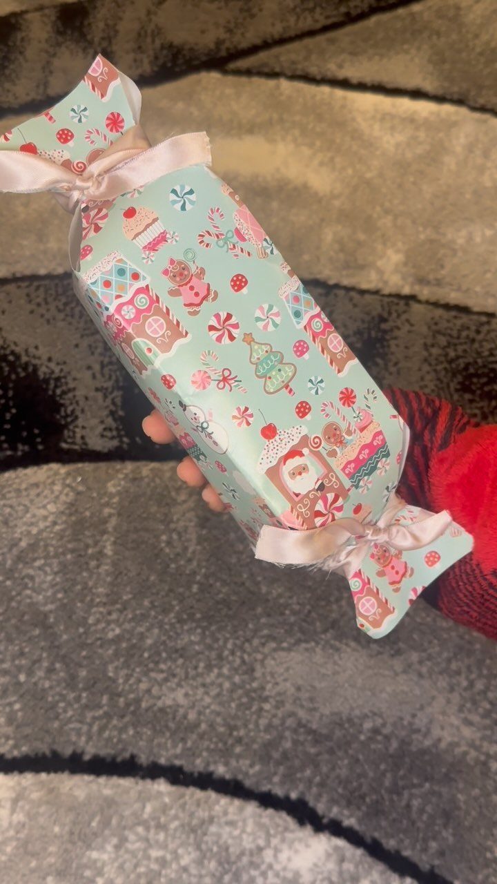 Christmas gift wrapped in blue patterned paper and tied like a candy wrapper