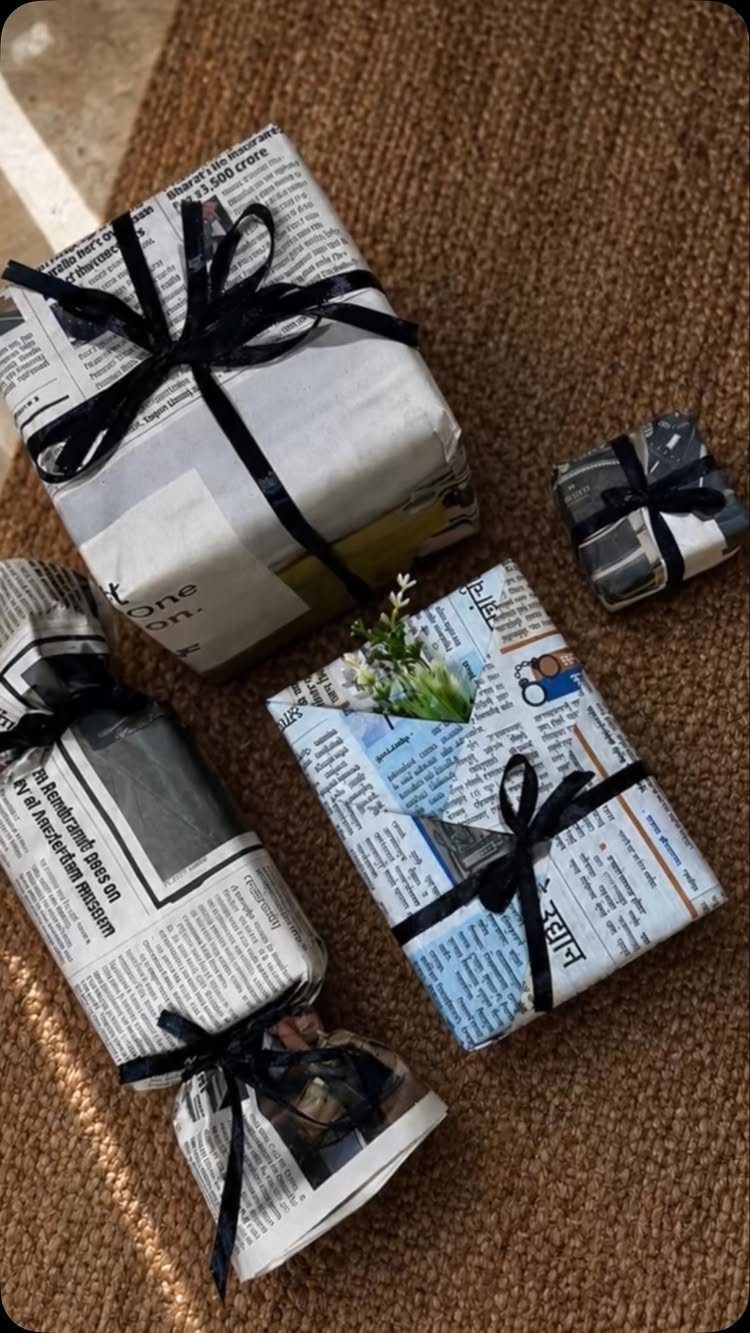 Newspaper-wrapped gifts tied with black ribbons on a brown woven mat