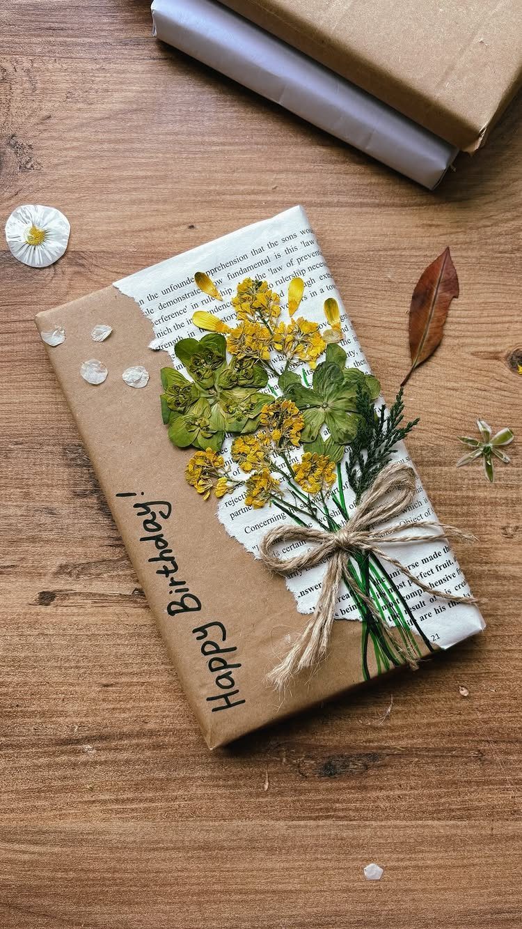 Gift wrapped in brown paper and book pages decorated with dried yellow flowers