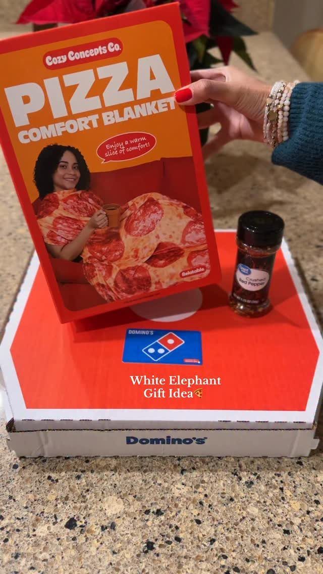 Pizza blanket package and red pepper flakes on a Domino's pizza box.