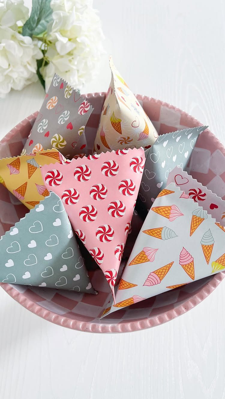 Cone-shaped gift bags made from patterned wrapping paper in a pink bowl