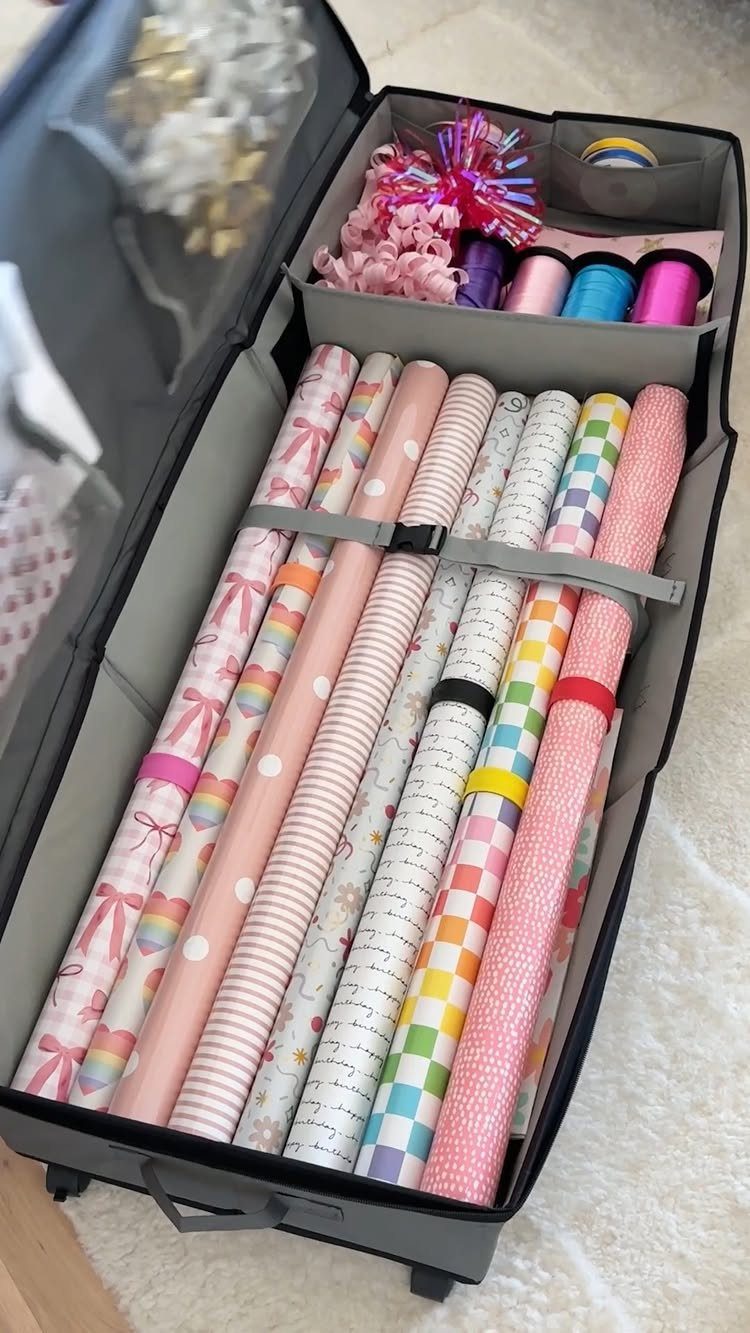 Wrapping paper rolls and ribbons organized inside a grey fabric storage bag.